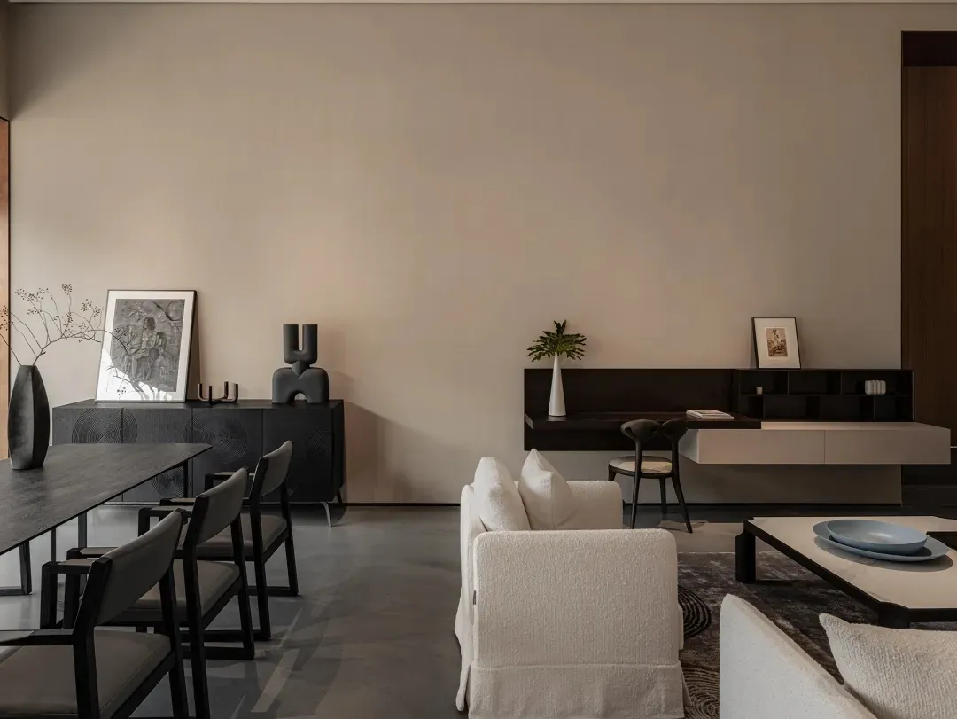 Modern living room with a minimalist design, featuring neutral-toned furniture and sleek, dark wood accents.