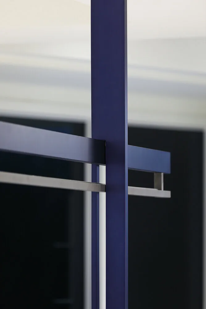 A minimalist architectural structure featuring metallic and glass components.