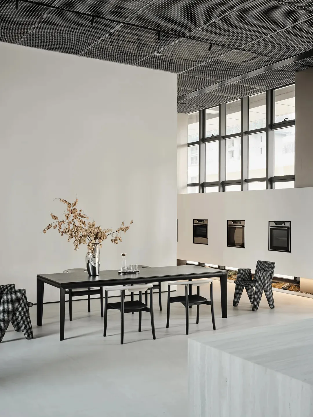 Modern commercial space with white concrete floors, glass windows, and minimalist design.