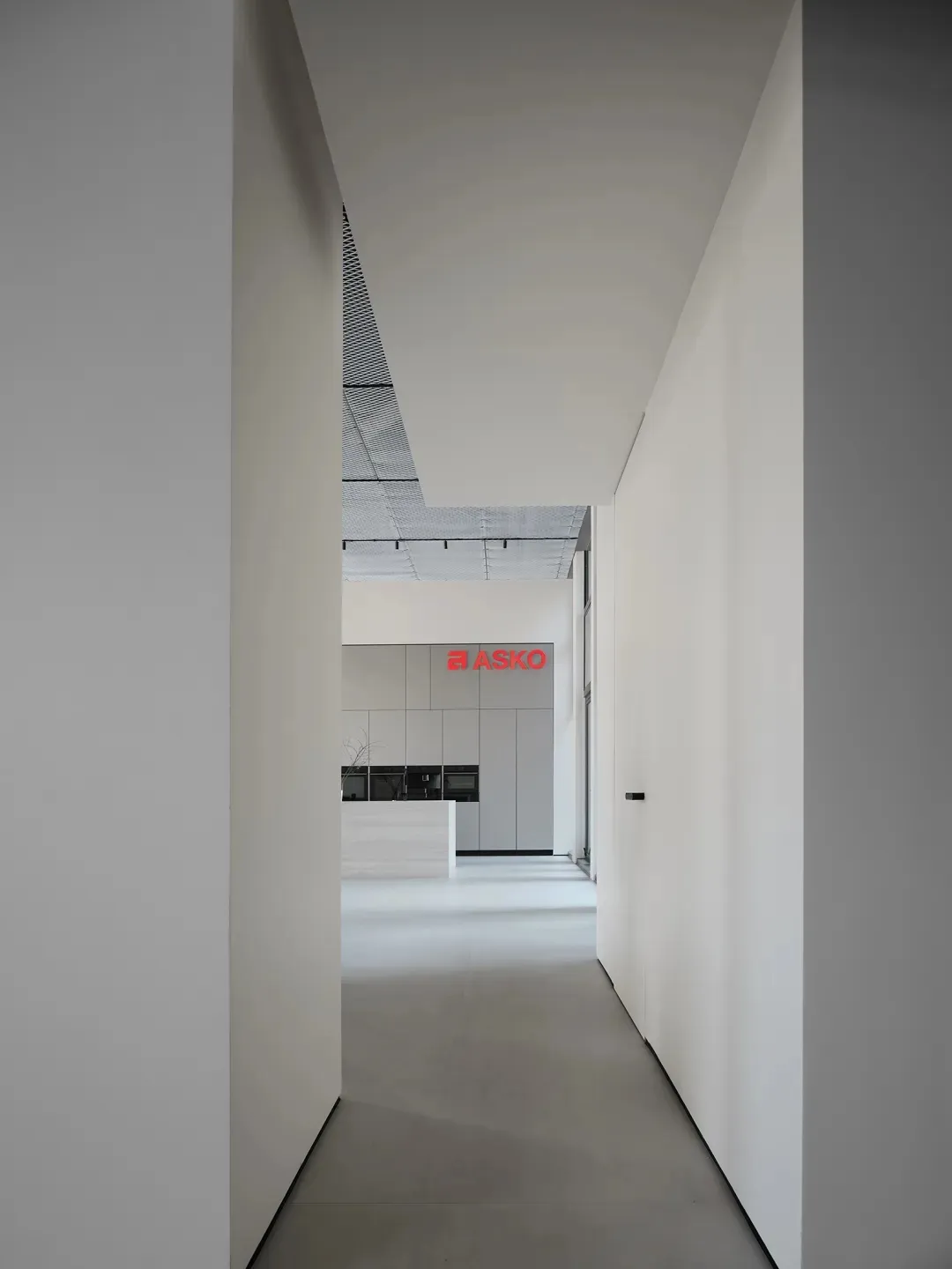 Modern minimalist office space with white walls and sleek design features.