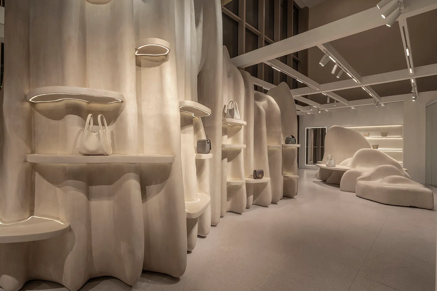 A modern retail shop with smooth, sculptural concrete forms and minimalist lighting.