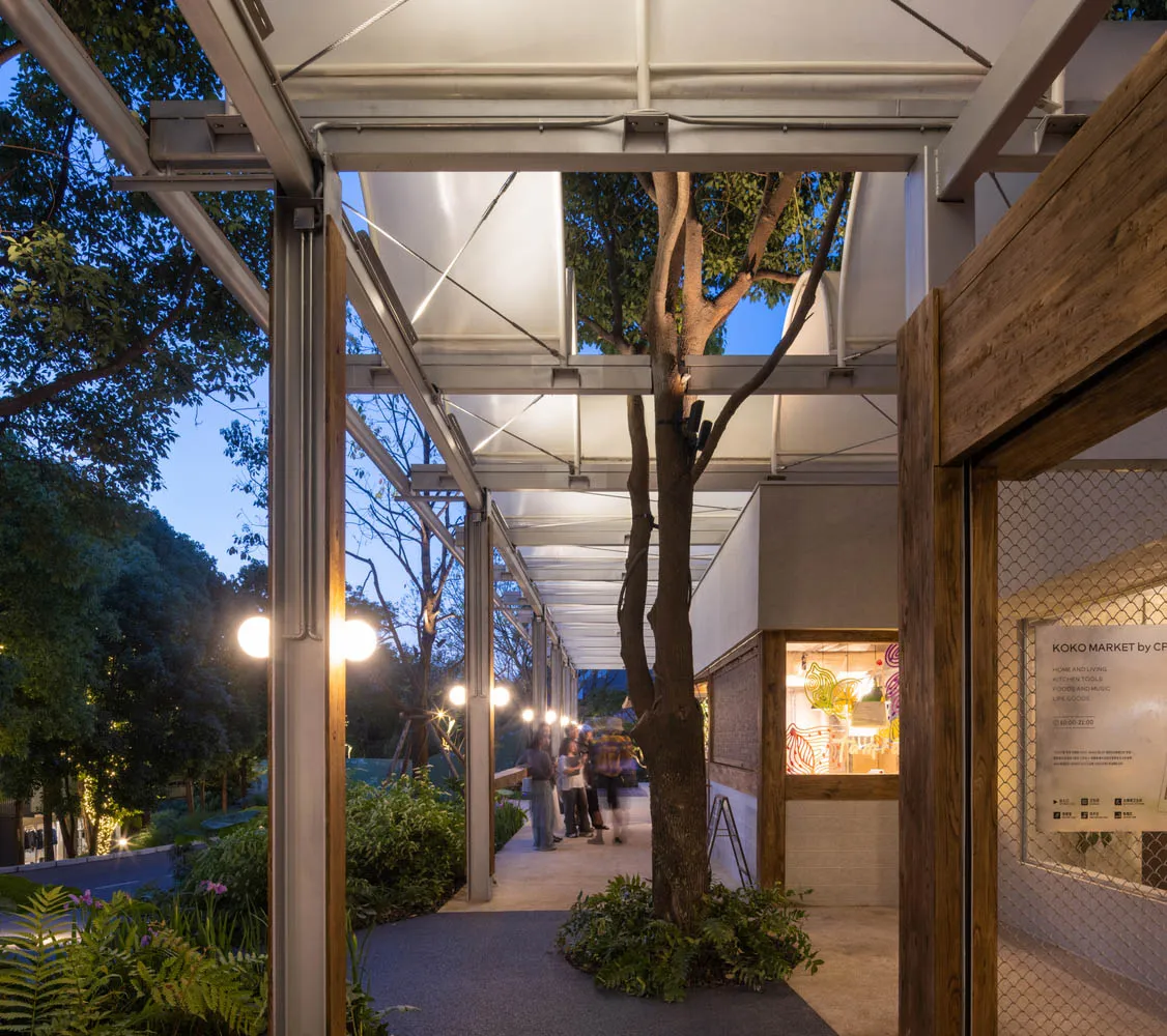 現代都市公園入口,設有金屬遮棚、木質結構與布面天花板。