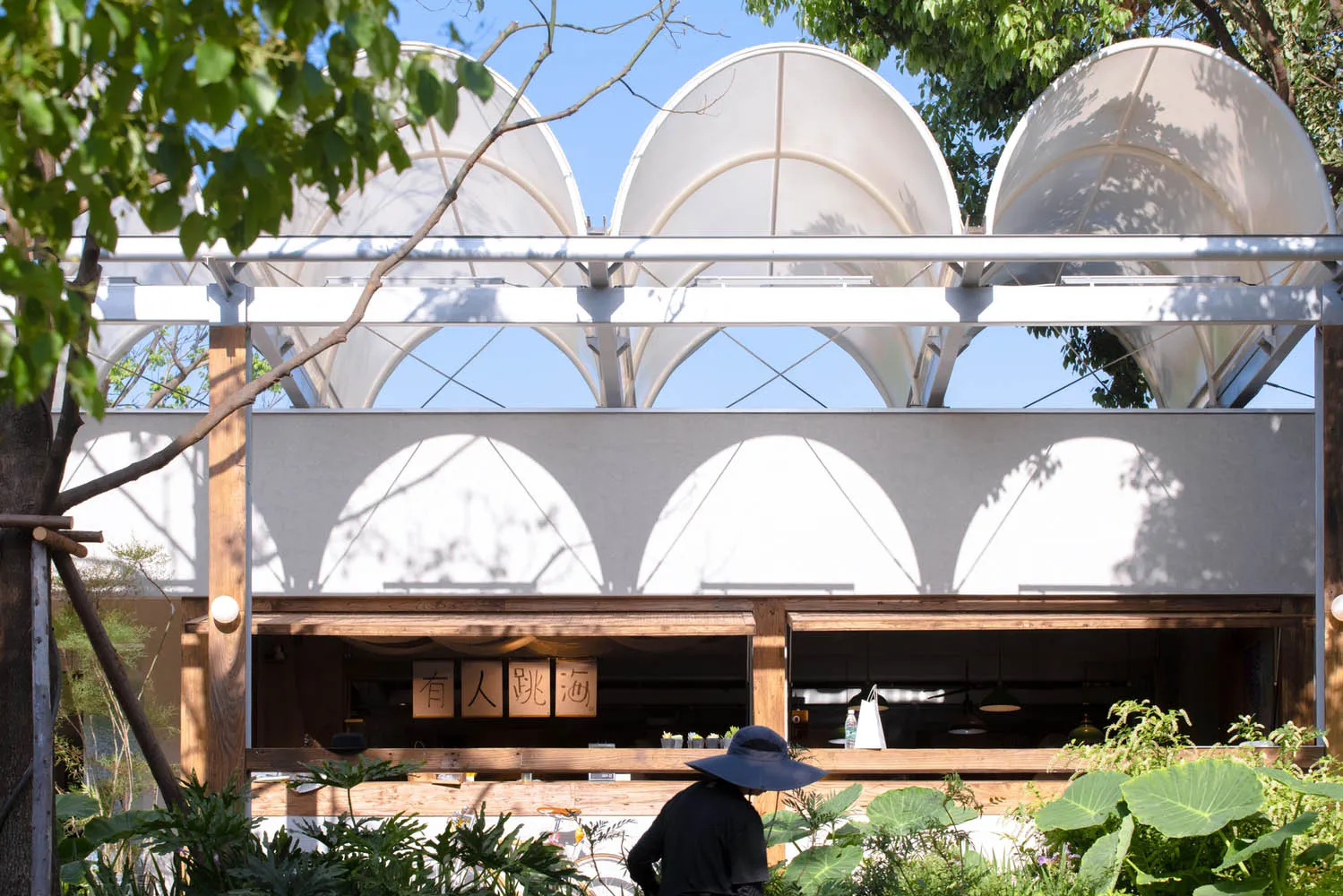 Modern cafe exterior with metal, glass, and wooden structural elements.
