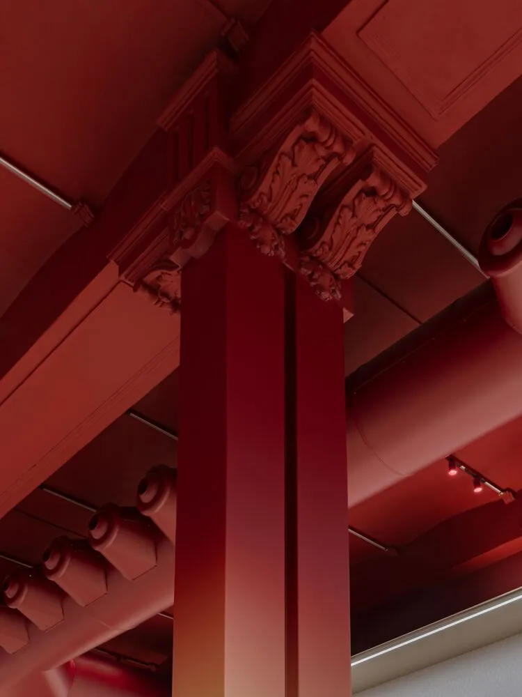 室內空間中的紅漆建築柱，突顯當代建築中鮮豔色彩的運用