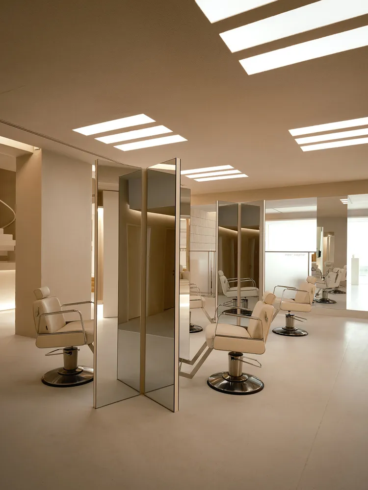 Modern salon interior with mirrors, leather, and cement floors