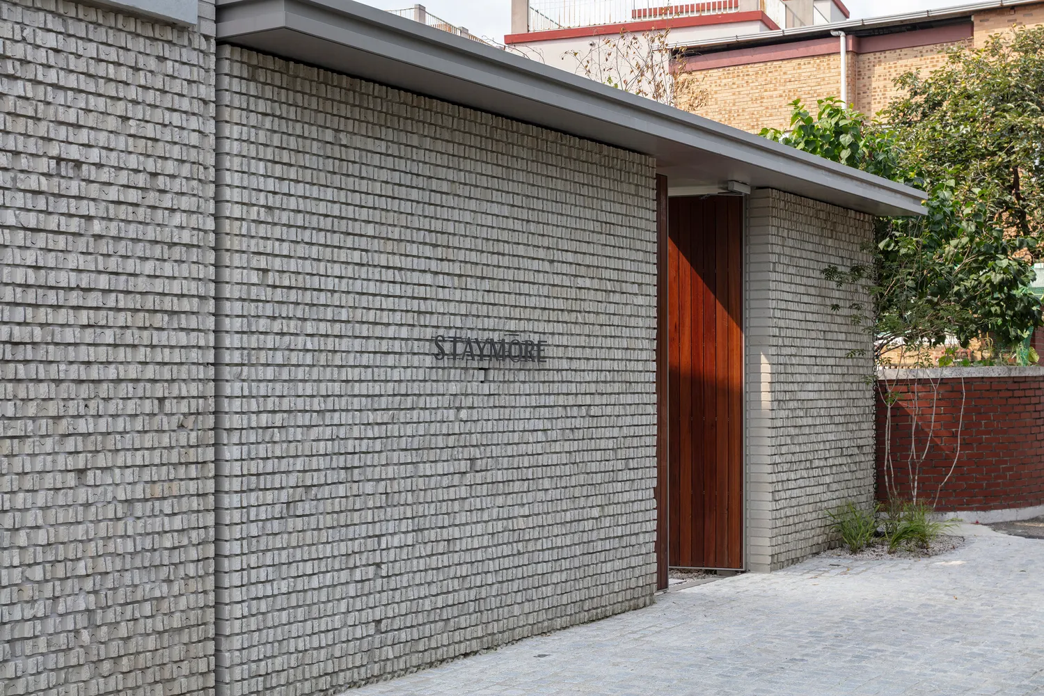一棟現代磚造建築外觀，設有「StayMore」招牌。