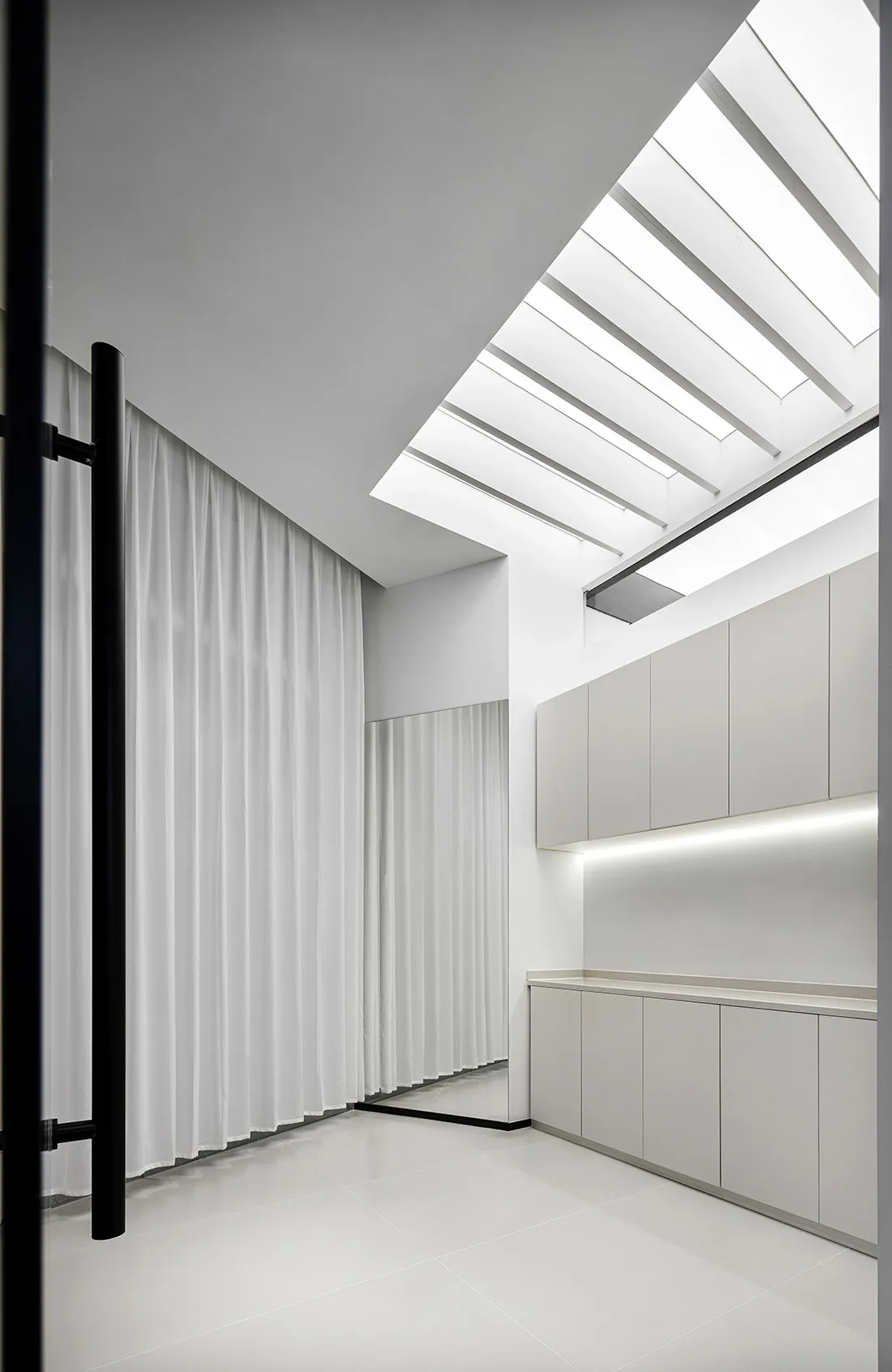 Modern bathroom featuring white concrete tiles and glass elements.