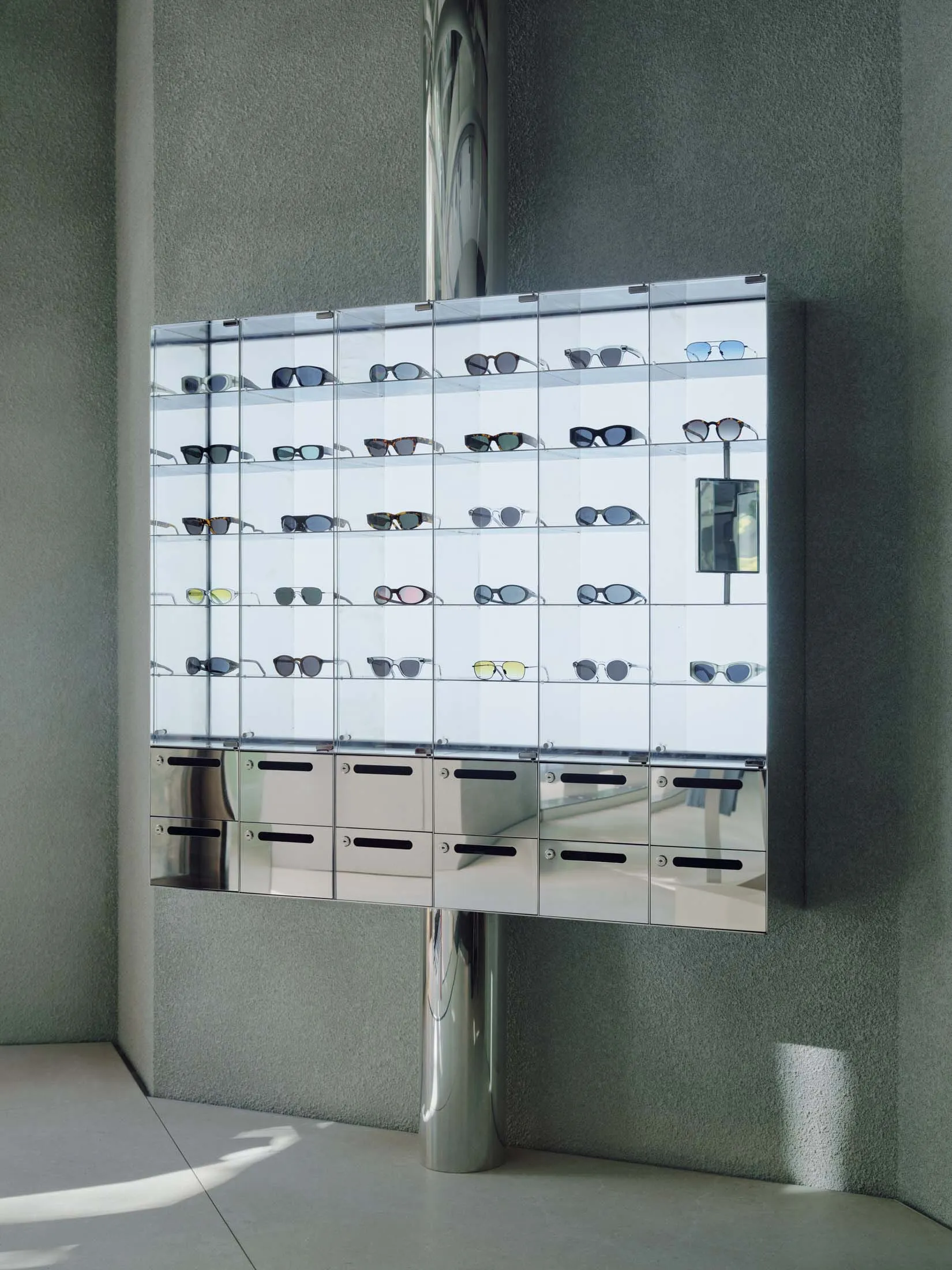 A glass display case filled with various sunglasses arranged neatly on shelves.