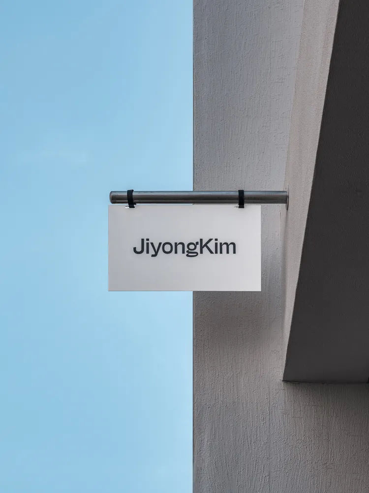 極簡風格的鋼製招牌,上面刻有「Jiyong Kim」的名字。