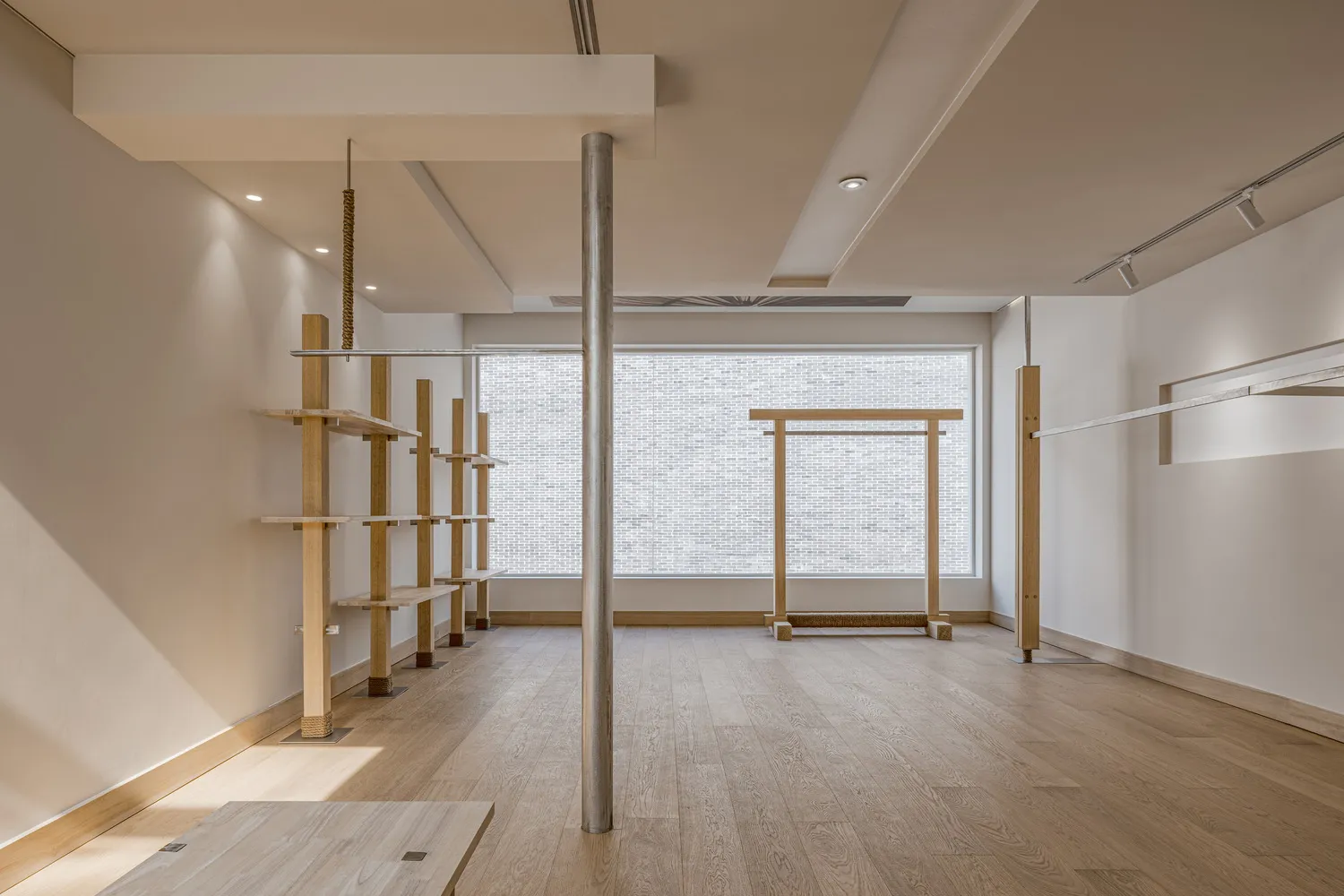 An empty, modern fitness center with wooden flooring, open space, and minimalist design.