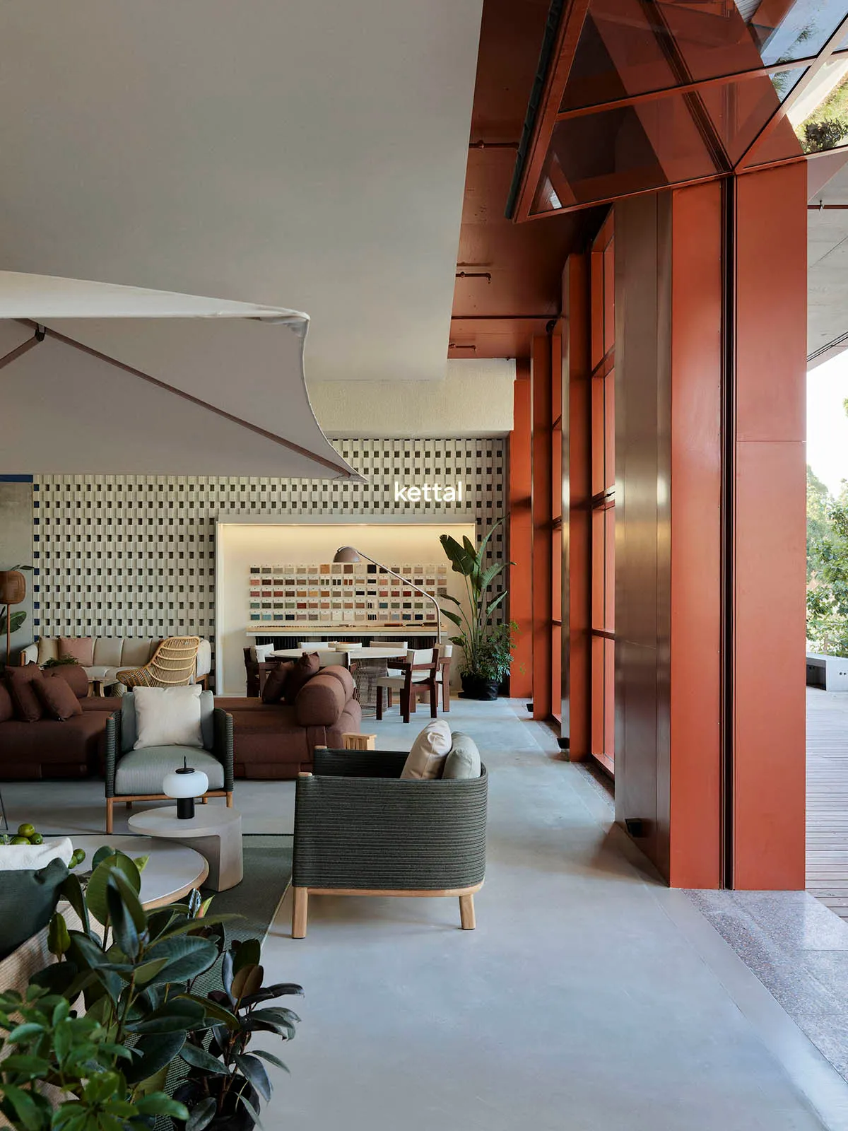 A modern living room featuring concrete flooring, wooden furniture, and potted plants.