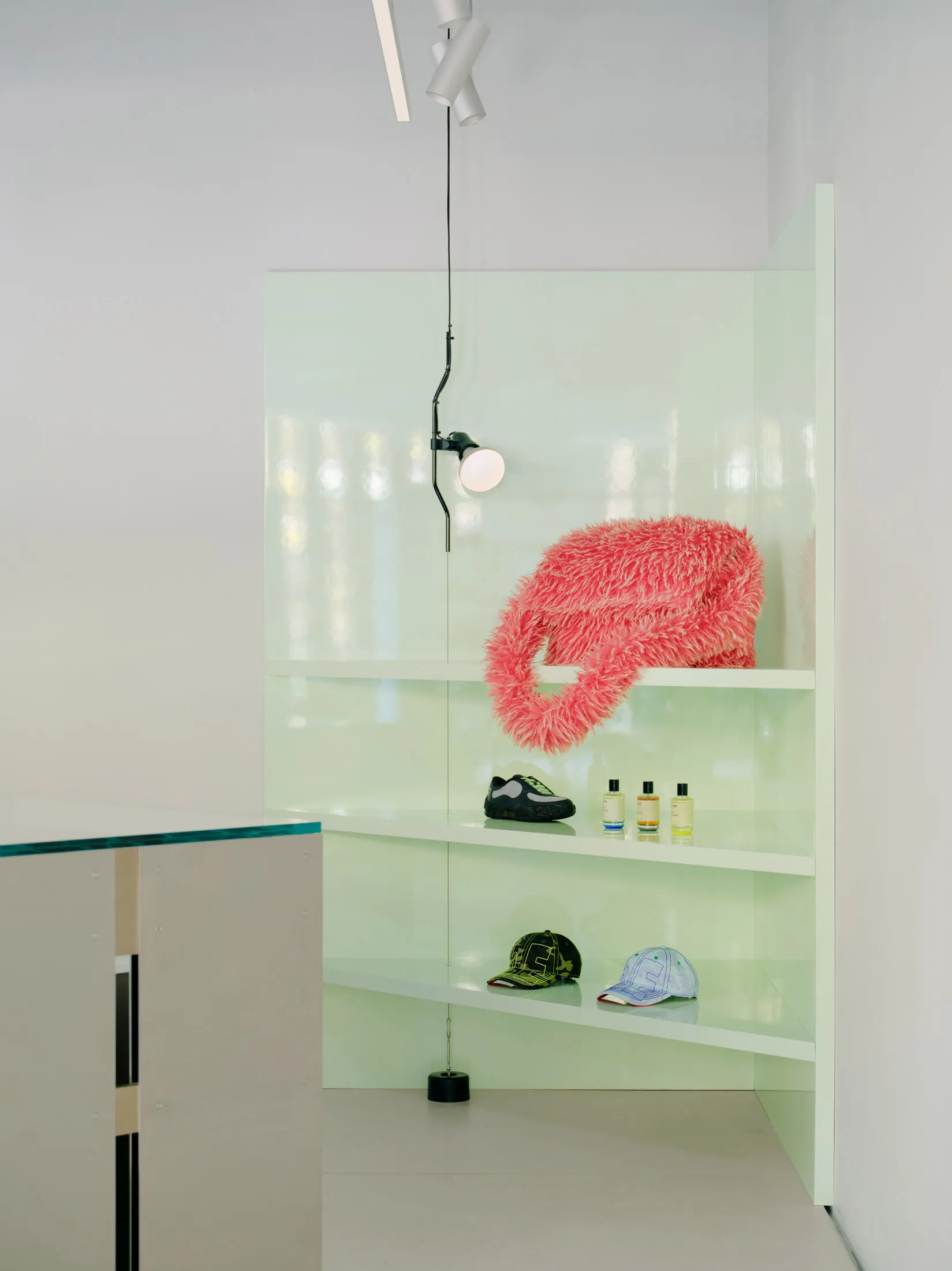A modern retail space featuring glass and metal shelving units with a glass and metal wheel on the floor.