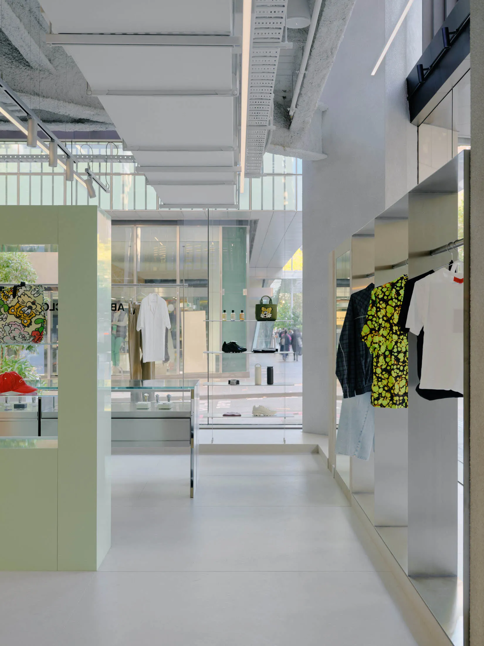 A modern retail store interior featuring concrete, glass, and metal materials.