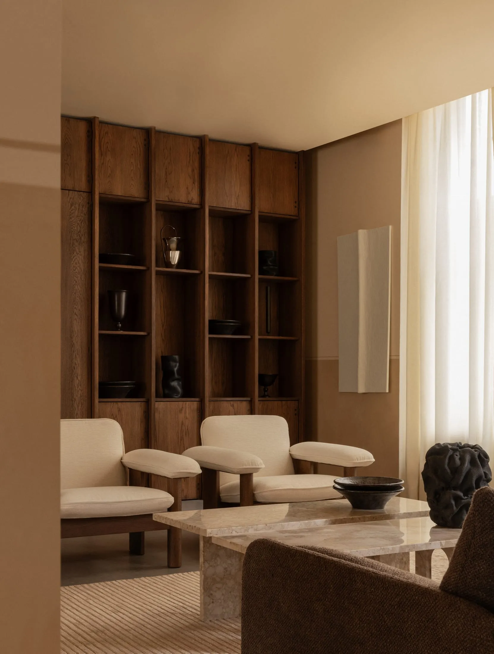 Lobby interior with wood cabinetry, marble table, and fabric seating
