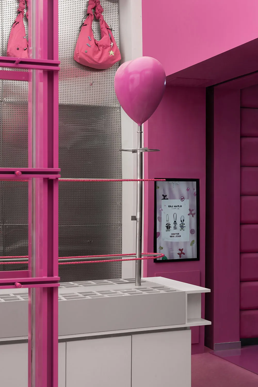 A minimalist retail display featuring glass and pink accents.