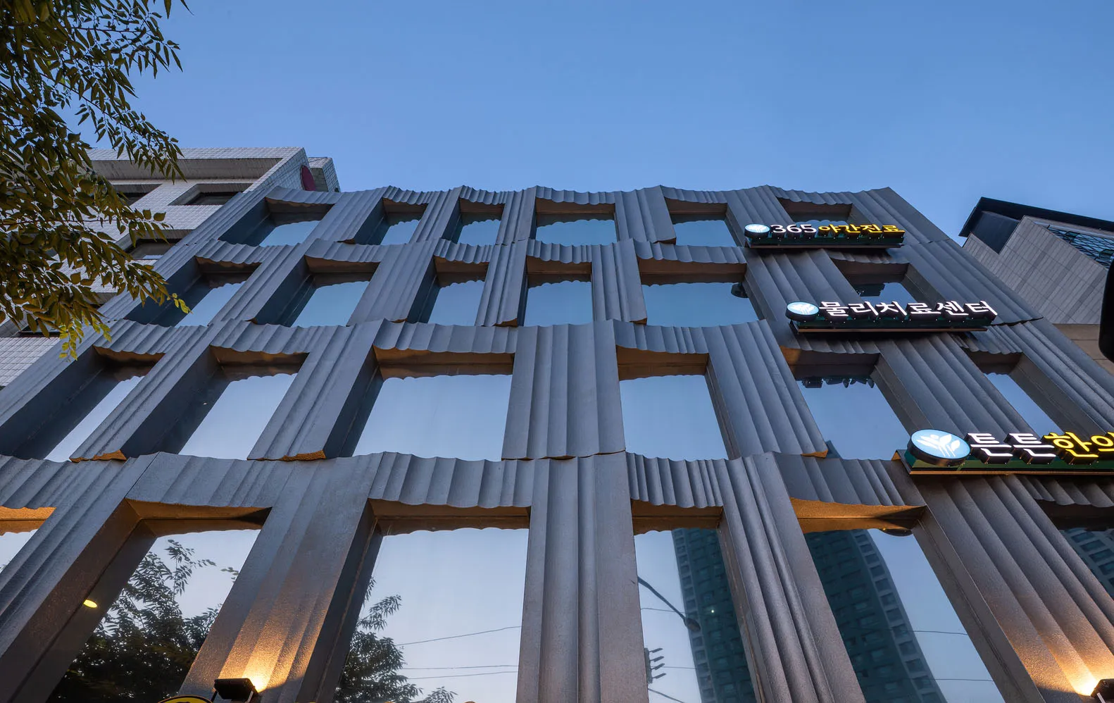 一座現代建築，擁有金屬立面與反光玻璃窗。