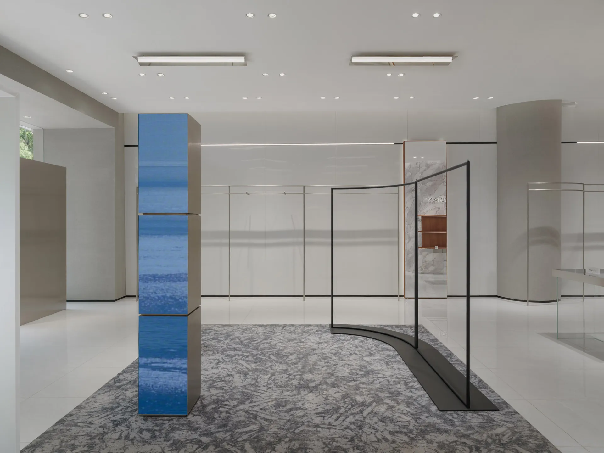 A minimalist retail store with glass, metal, and marble materials.