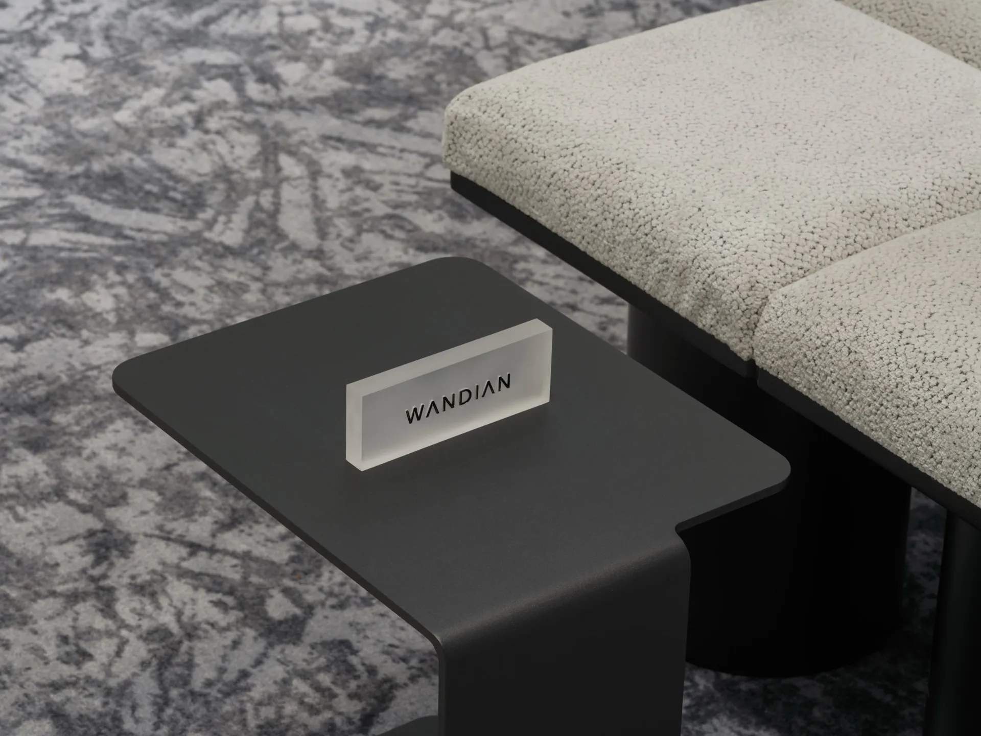 Modern interior design featuring a sleek black metal side table with a frosted glass label displaying 'Wandian'.