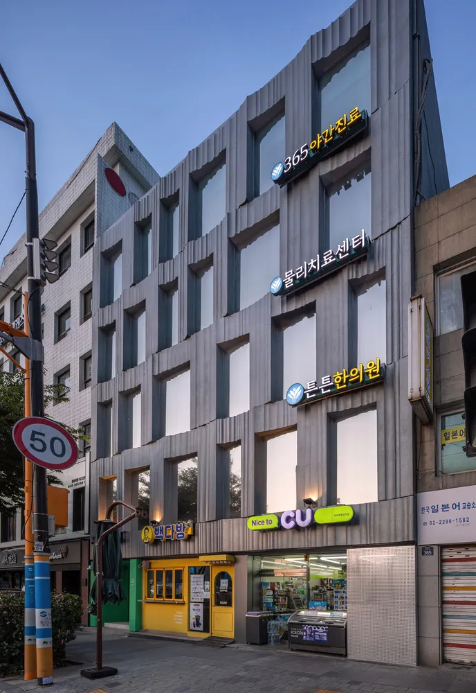 Modern storefront with glass windows and concrete facade.