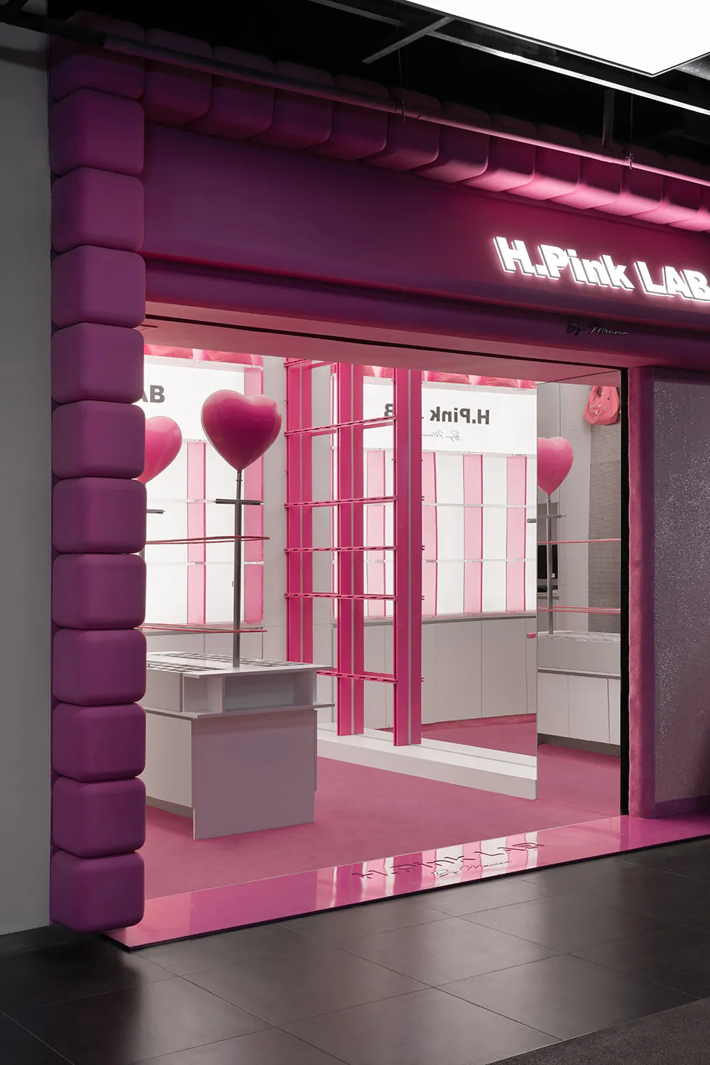 Modern retail storefront with pink furniture and decorations.
