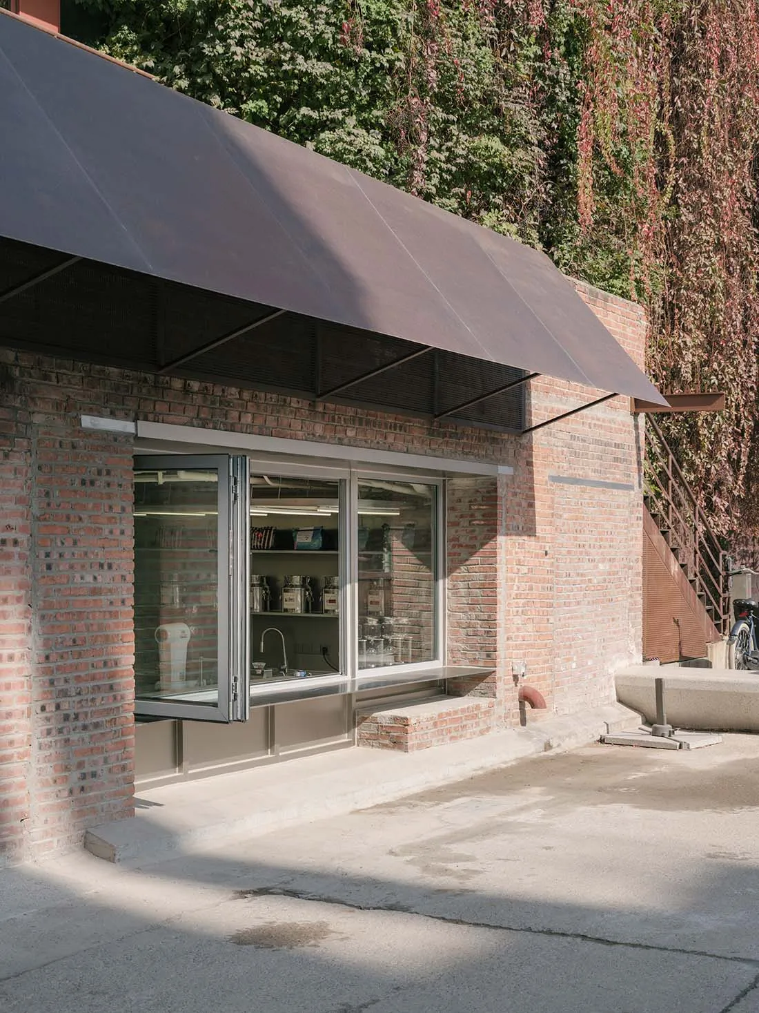 磚造店面外觀,門敞開著,展示店內零售商品。