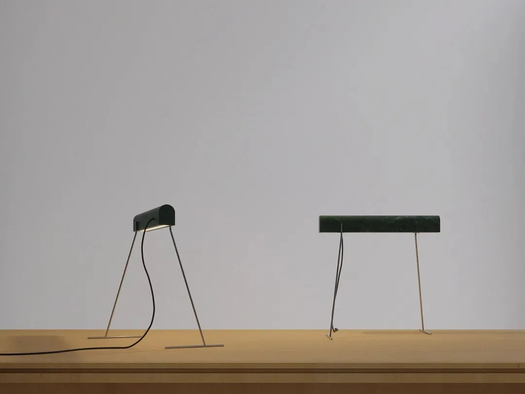 A modern desk lamp with a marble base, lying flat on a wooden surface.