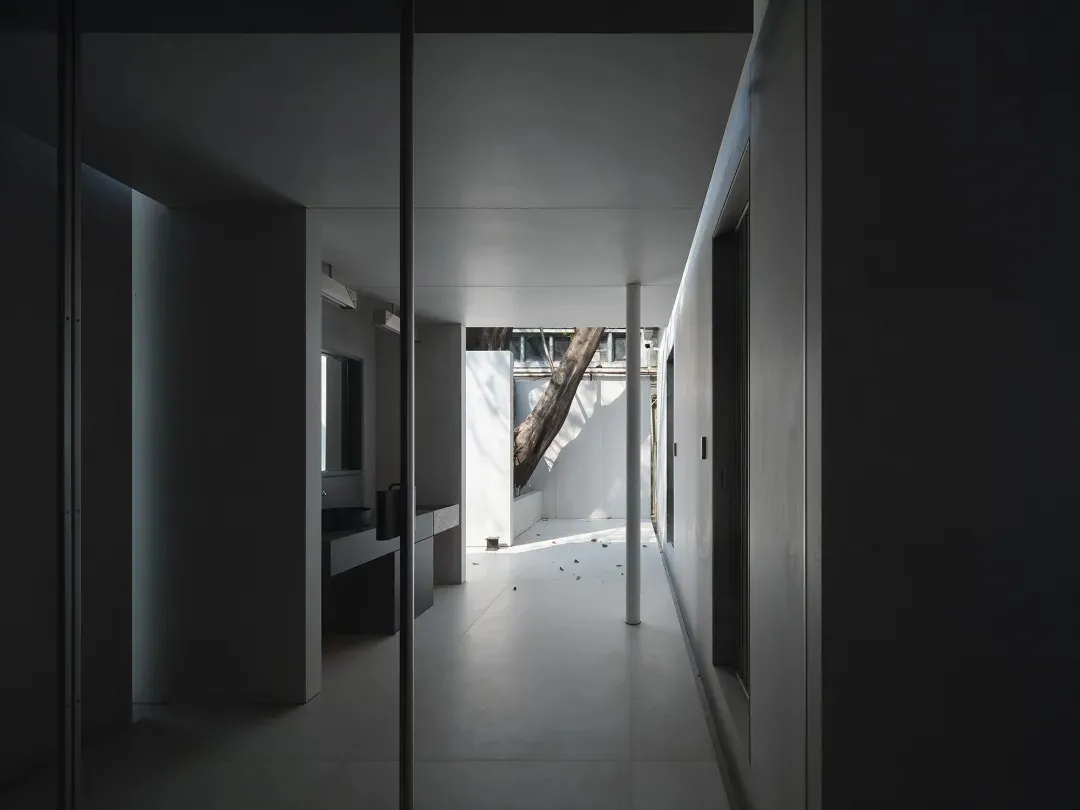 A minimalist living room featuring concrete walls and modern furniture.