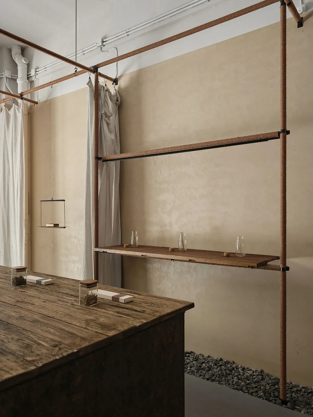Industrial-style coffee shop interior featuring exposed wood, metal, and rope shelving.
