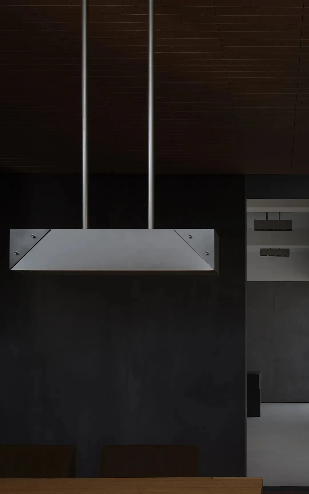 Modern kitchen interior with minimalist design, featuring metal hood and dark wood accents.