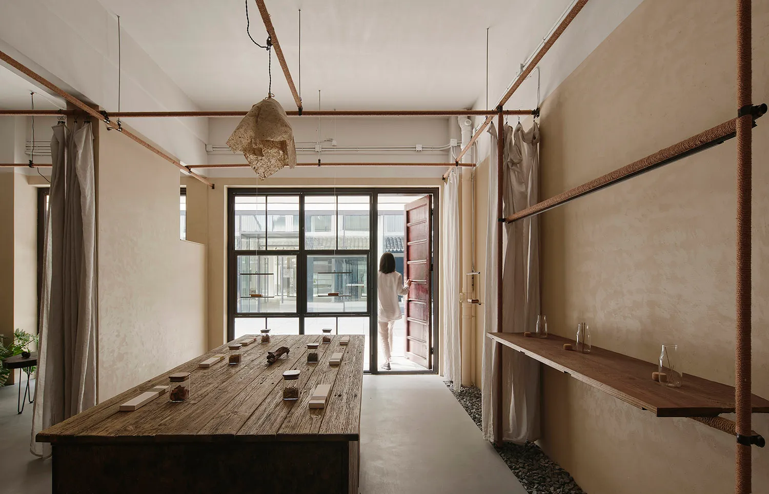 A minimalist restaurant interior with a wooden counter and various items on display.