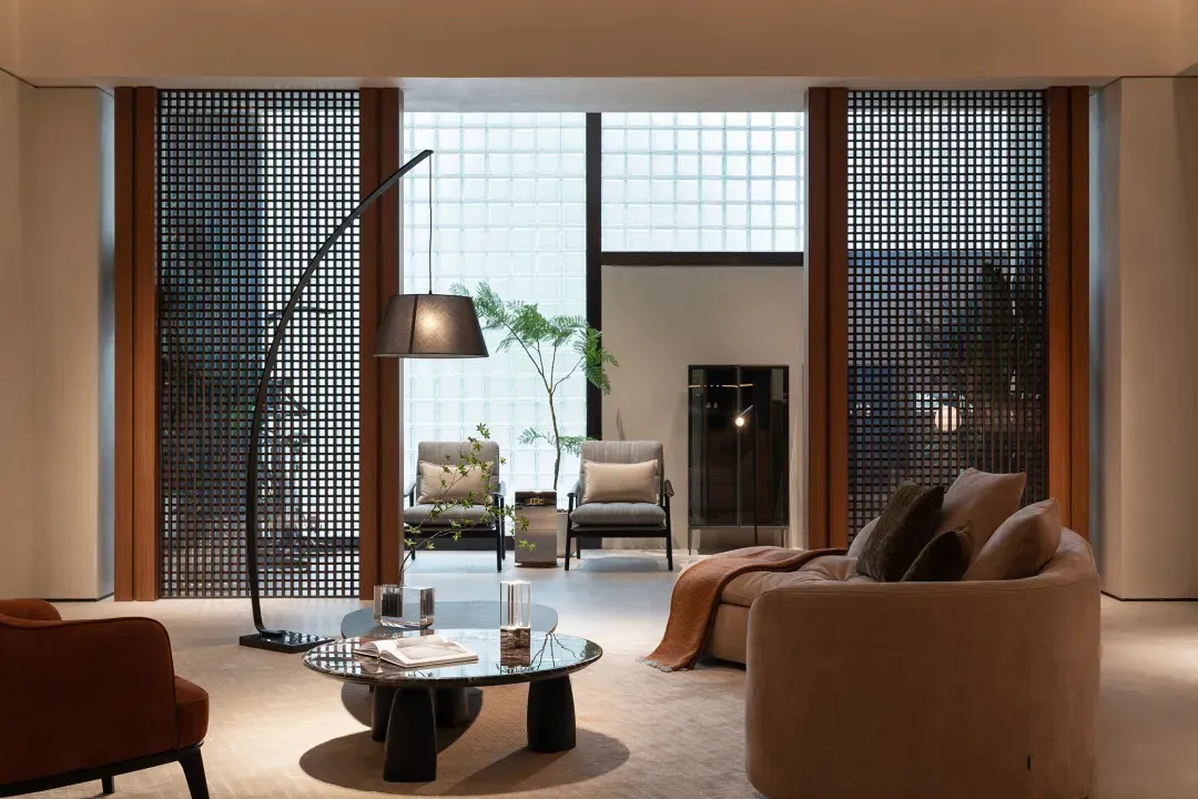 Modern living room featuring a sofa, chairs, coffee table, and decorative elements like a floor lamp and green plant.