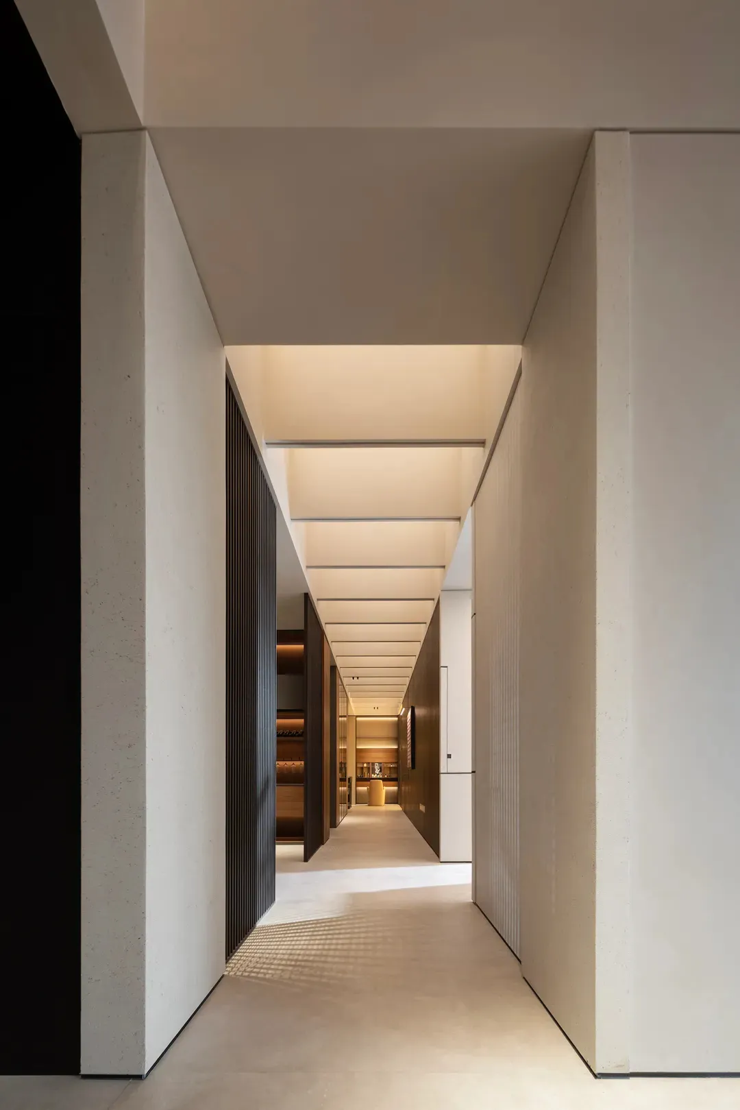 Modern minimalist corridor with concrete walls and a long hallway.