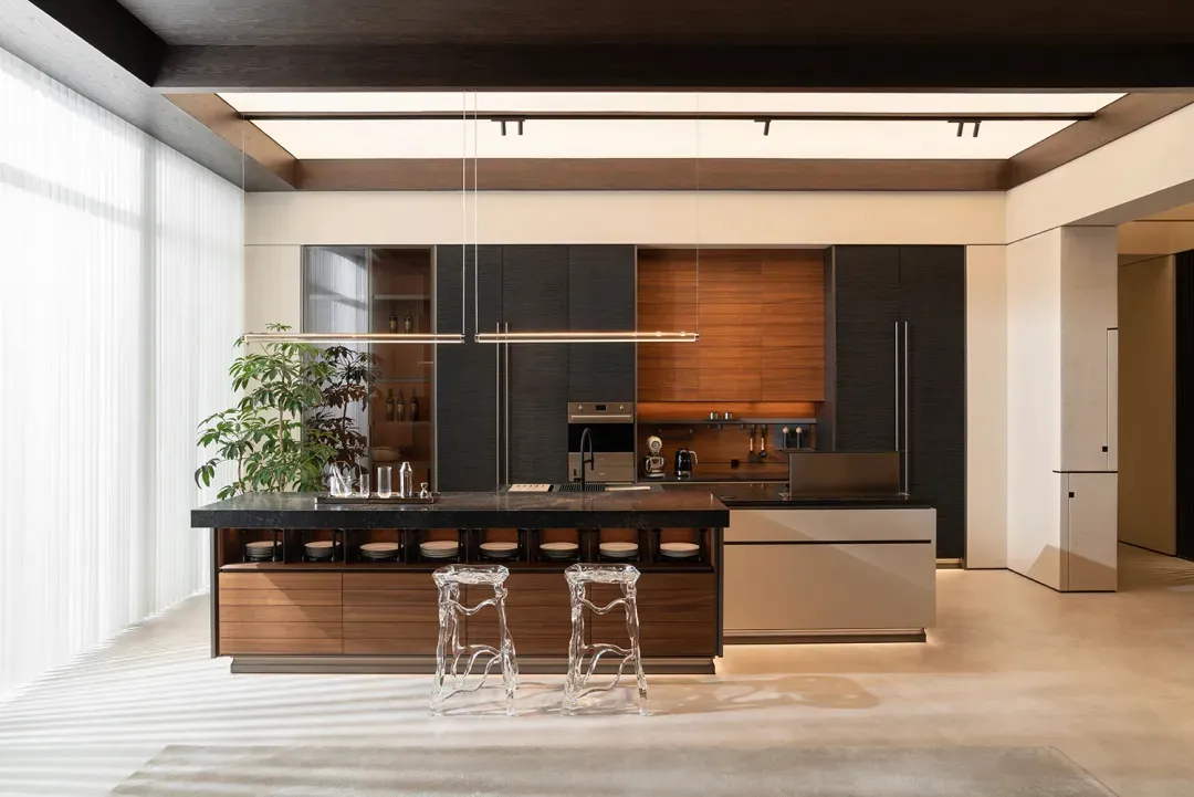 A modern residential kitchen featuring wood and metal materials, with a central island and stools.
