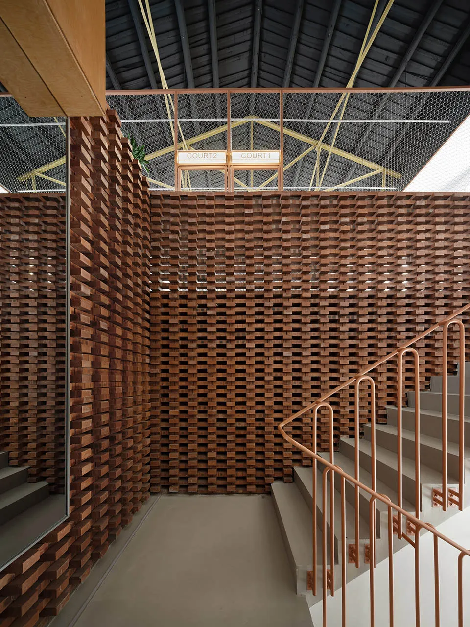A modern building interior with a wooden wall and stairs.