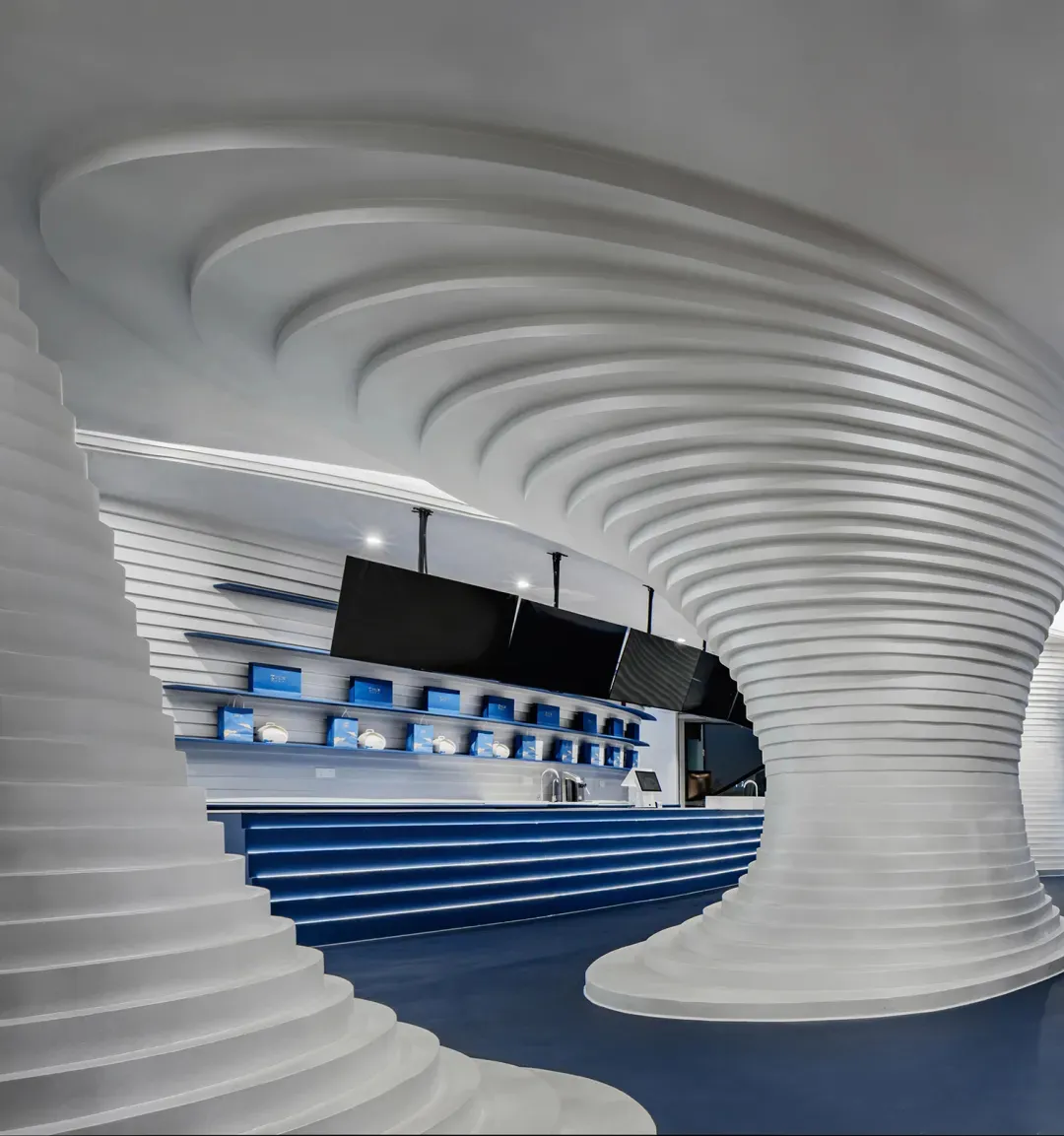 A modern retail space featuring plastic columns and a wave-like ceiling design.