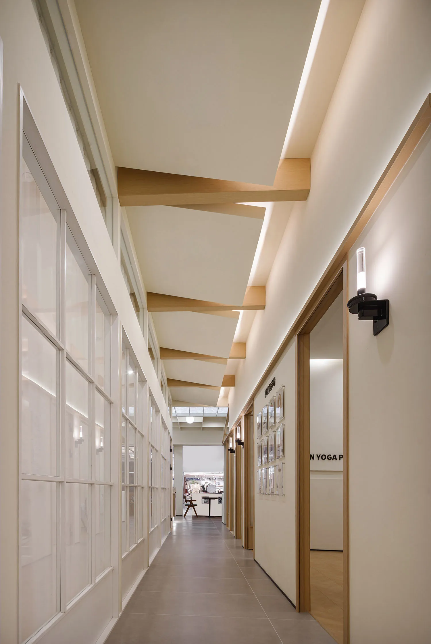 Modern, minimalist corridor with glass walls and warm lighting.