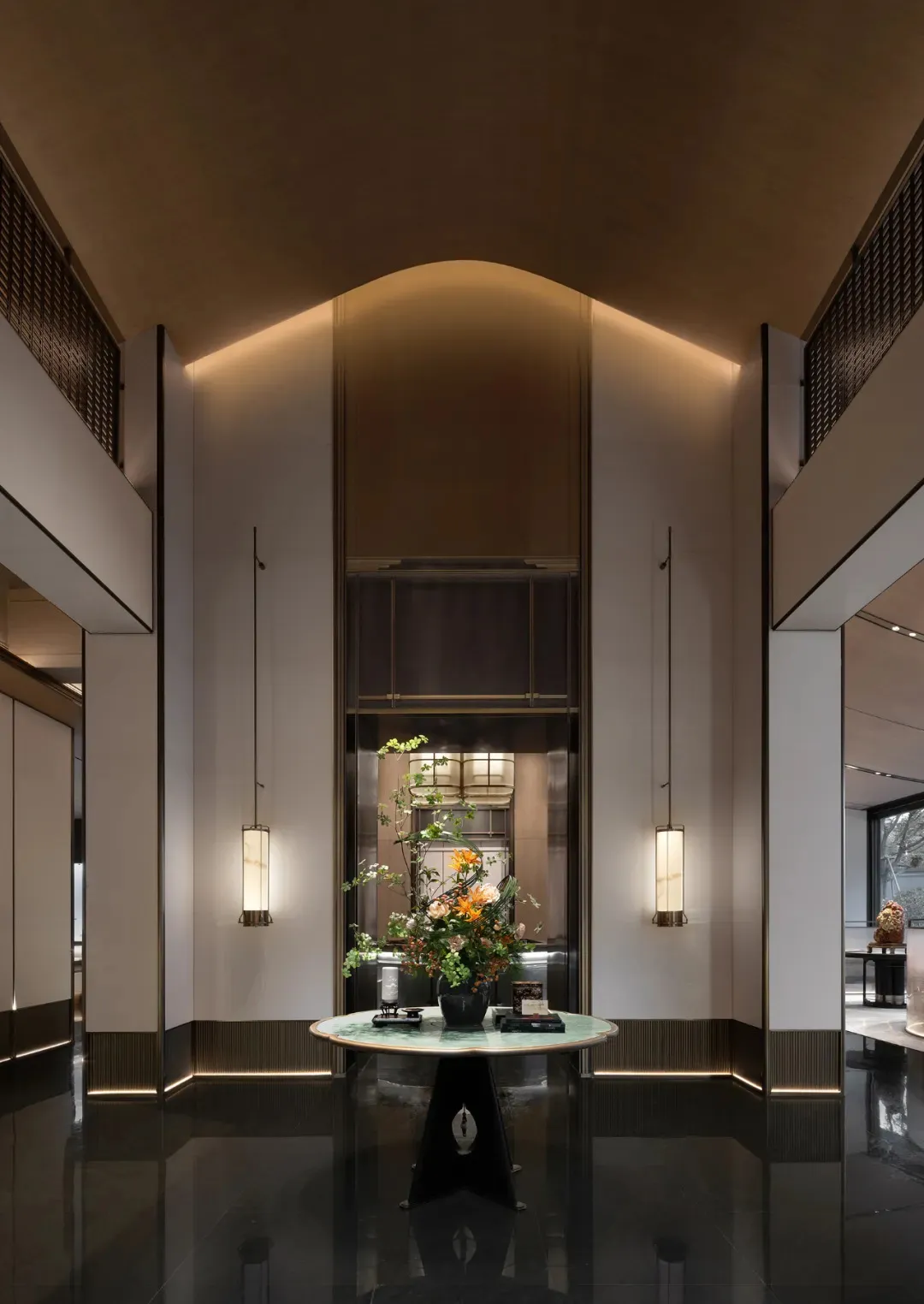 Modern lobby with marble floor, glass walls, and metal accents.
