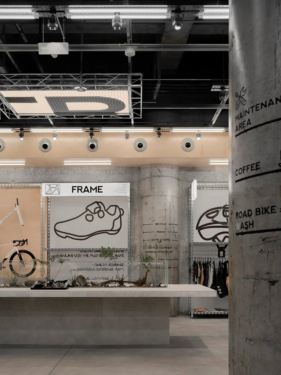 Industrial-style retail space with concrete materials, showcasing a frame design and clothing section.