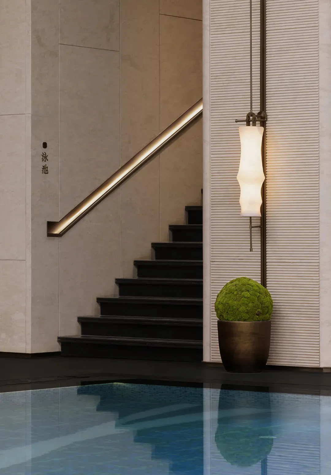 Modern spa interior with concrete walls and stairs leading to a pool.