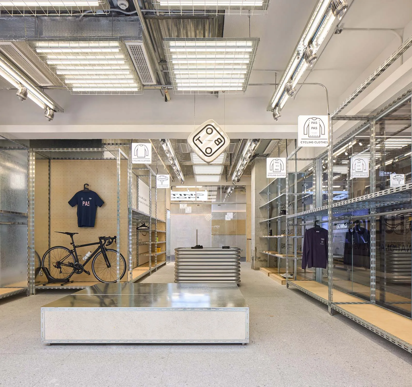A clothing retail space featuring industrial-style metal shelves and concrete floors.