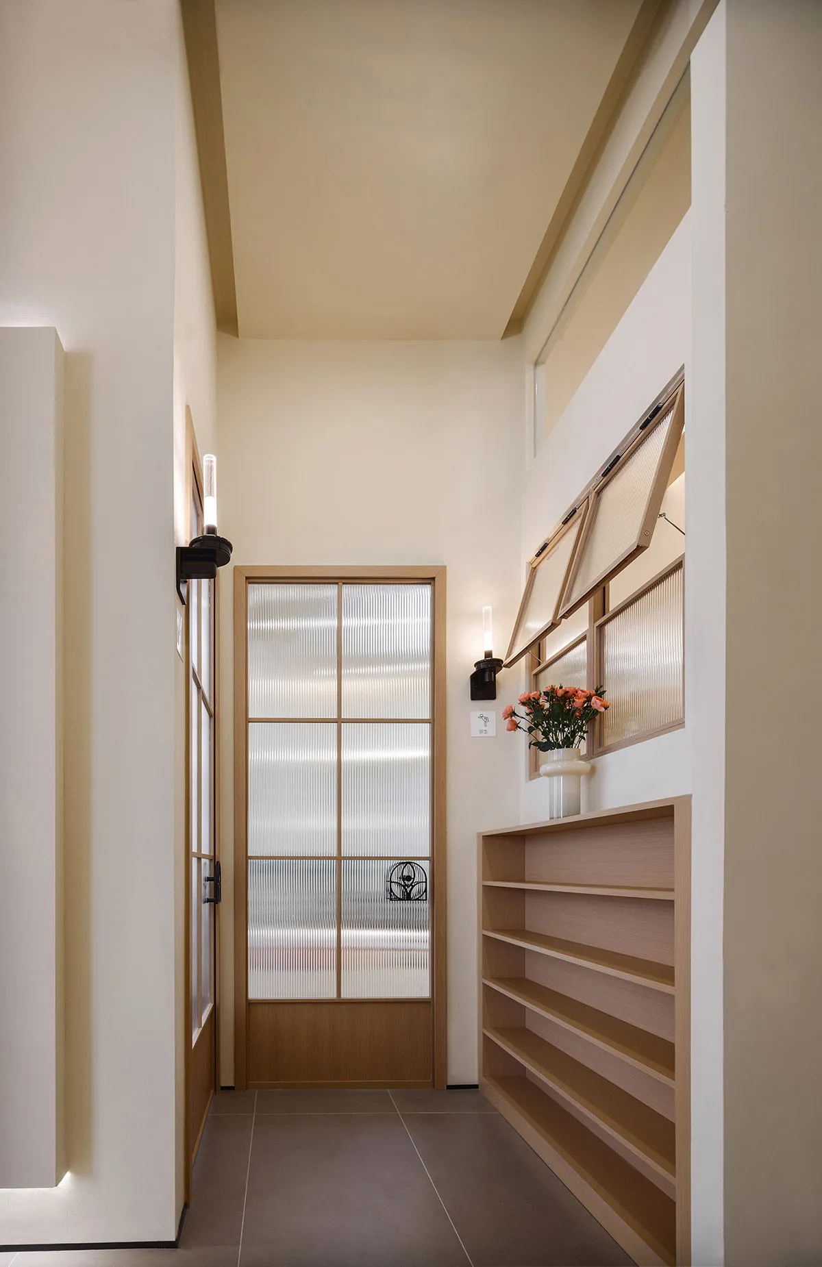 A corridor interior with wooden shelves, ceramic floor, and a glass door.