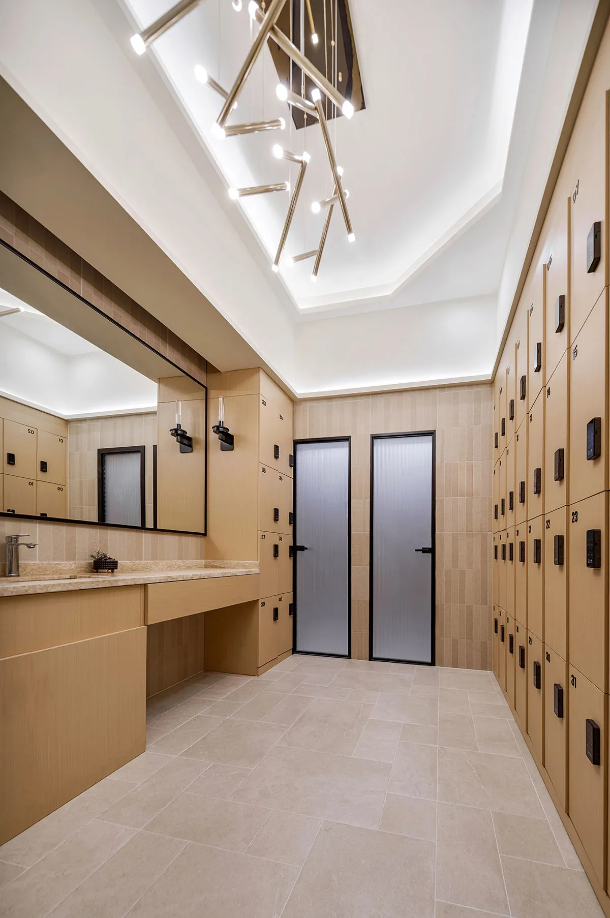 Modern minimalist locker room featuring tile floors and wood accents, with numbered lockers and a polished design.