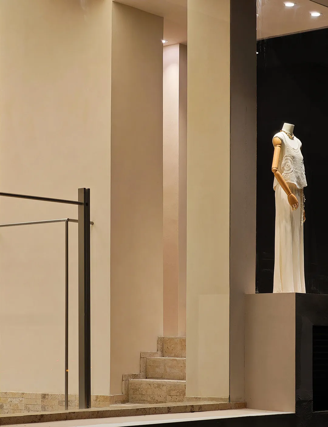 A mannequin dressed in a white ruffled dress, presented on a wooden form as part of a fashion exhibition display.