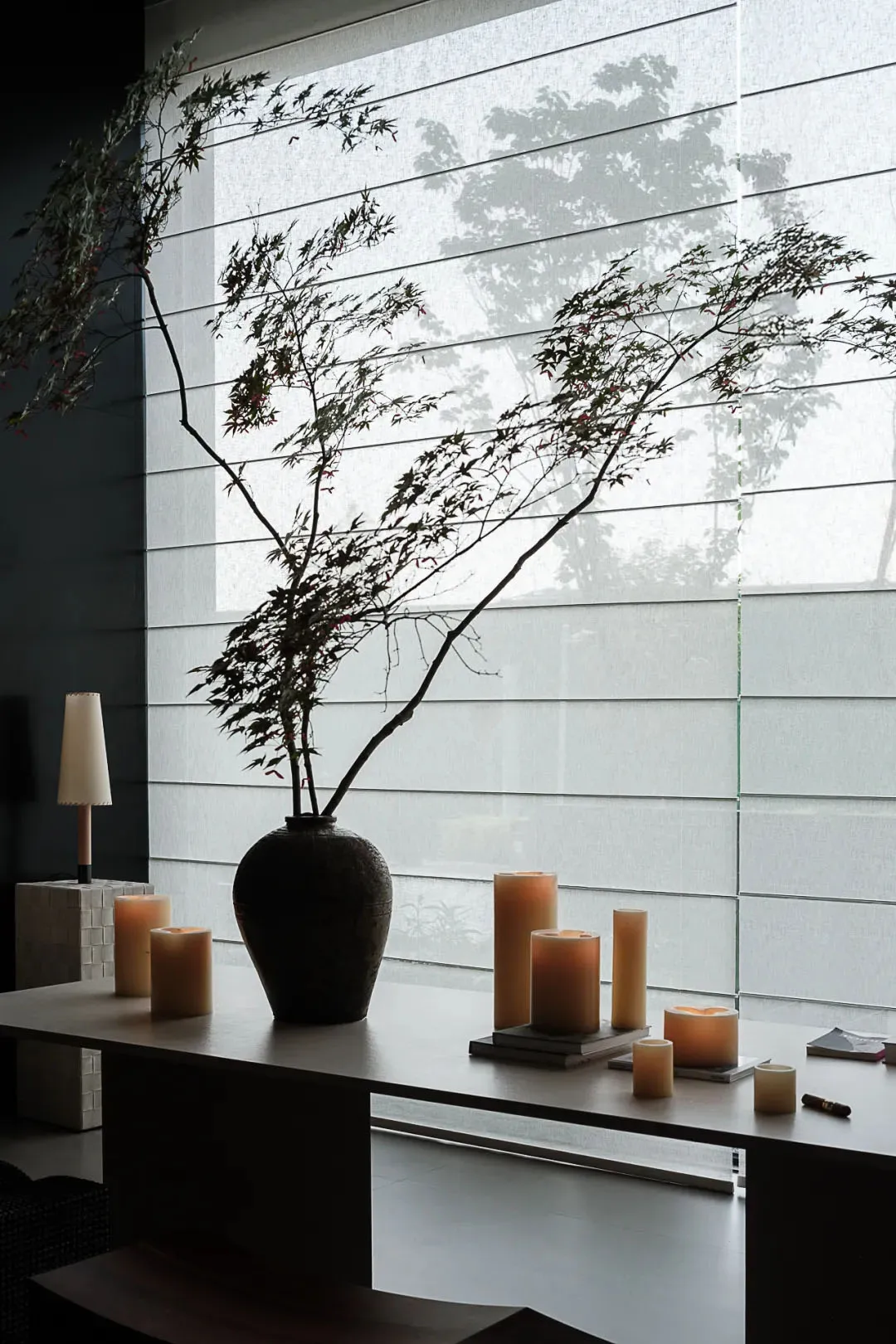 A minimalist interior space featuring a ceramic vase with a floral arrangement.