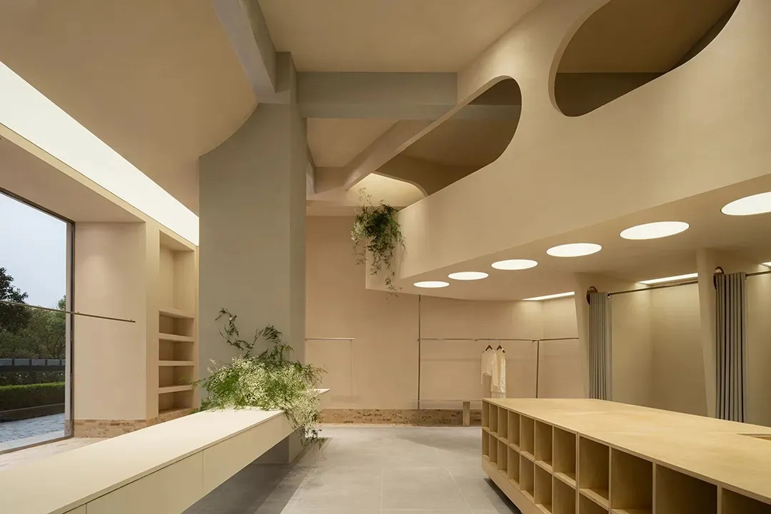 Minimalist cloakroom with neutral-toned materials and circular lighting fixtures.