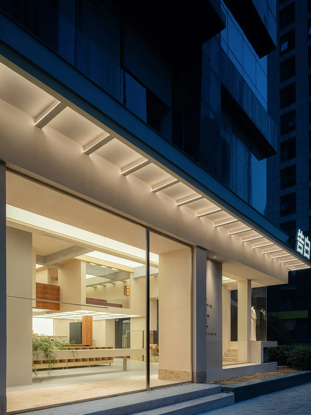 Modern retail storefront with large glass windows and concrete elements.