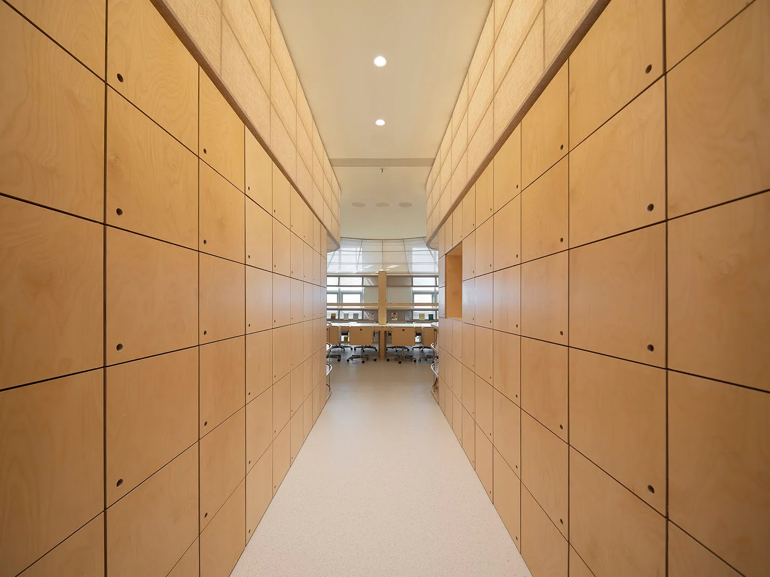 A minimalist office interior featuring wood-paneled walls.