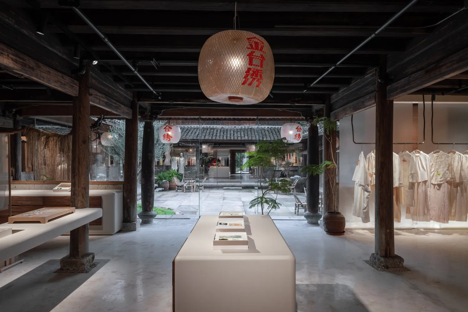 Modern retail store with wooden beams, concrete flooring, and white clothing racks.