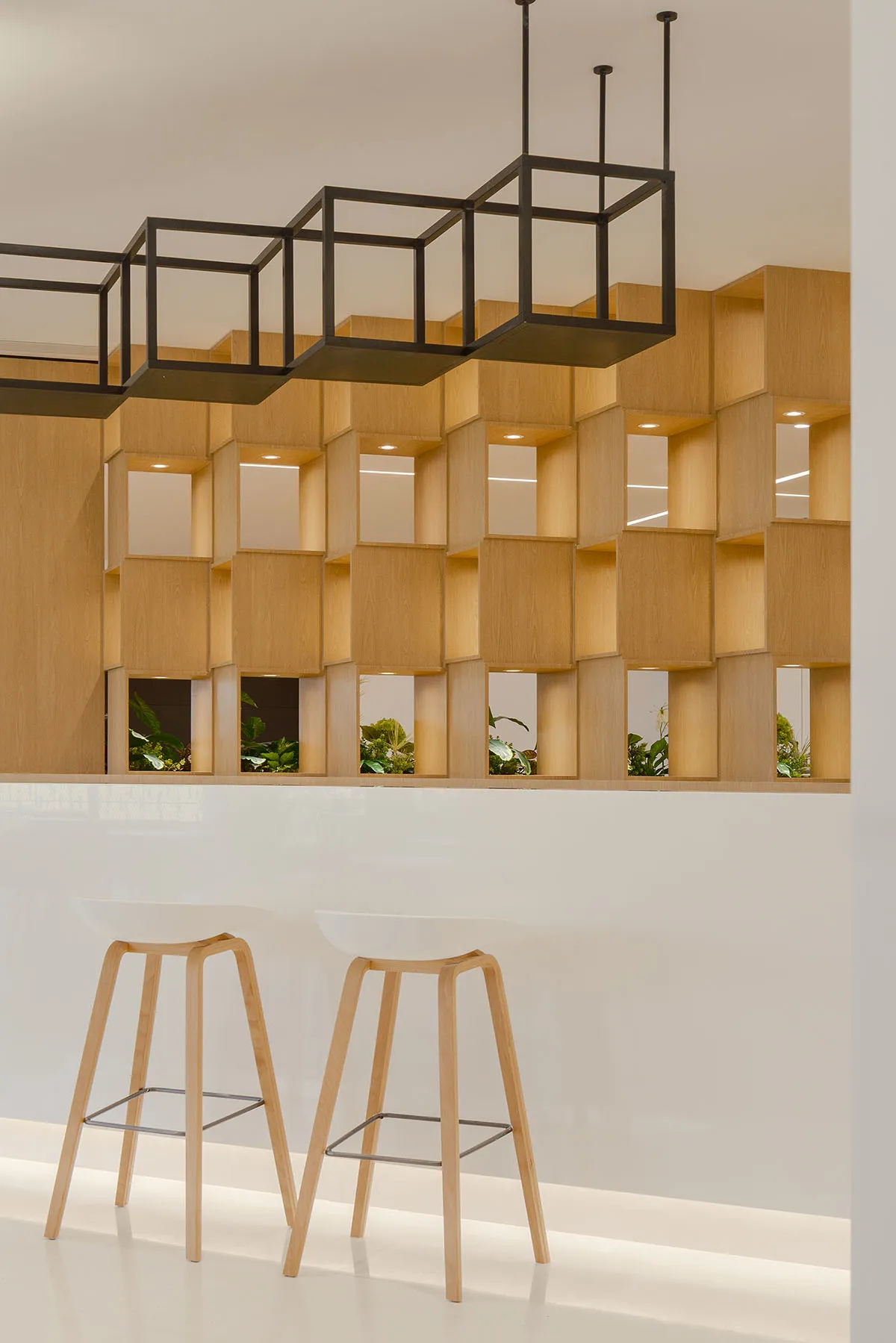 Contemporary bar area featuring wooden stools and square cubed shelves.