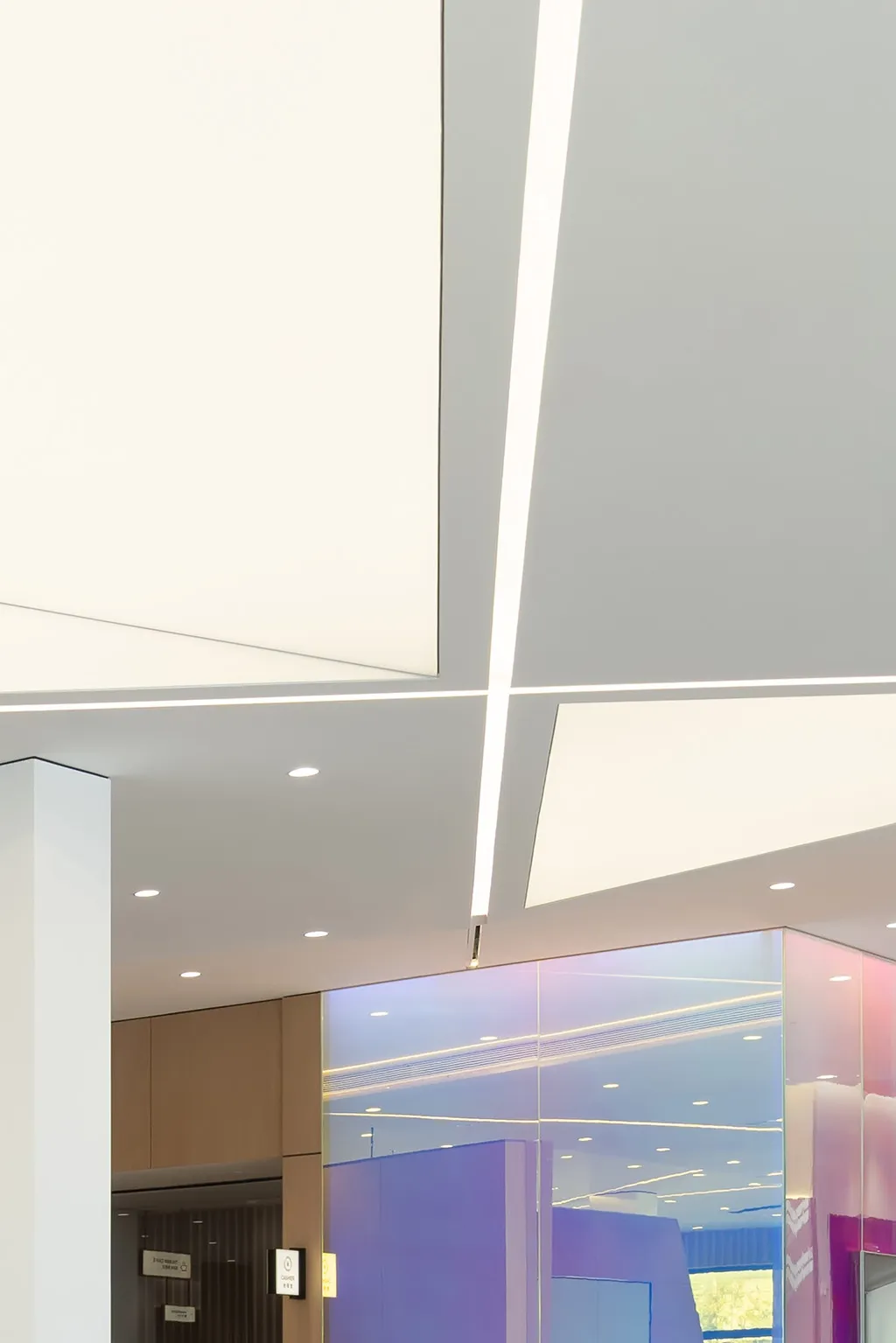 A modern office lobby featuring minimalist design with concrete and glass materials.